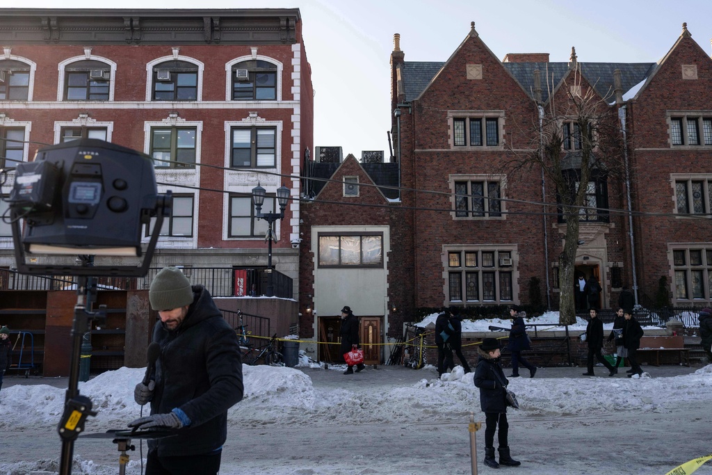 Members of the media work near the scene where a car slammed into the entrance of the Chabad Lubavitch world headquarters, Thursday, Jan. 29, 2026, in New York. (AP Photo/Yuki Iwamura)