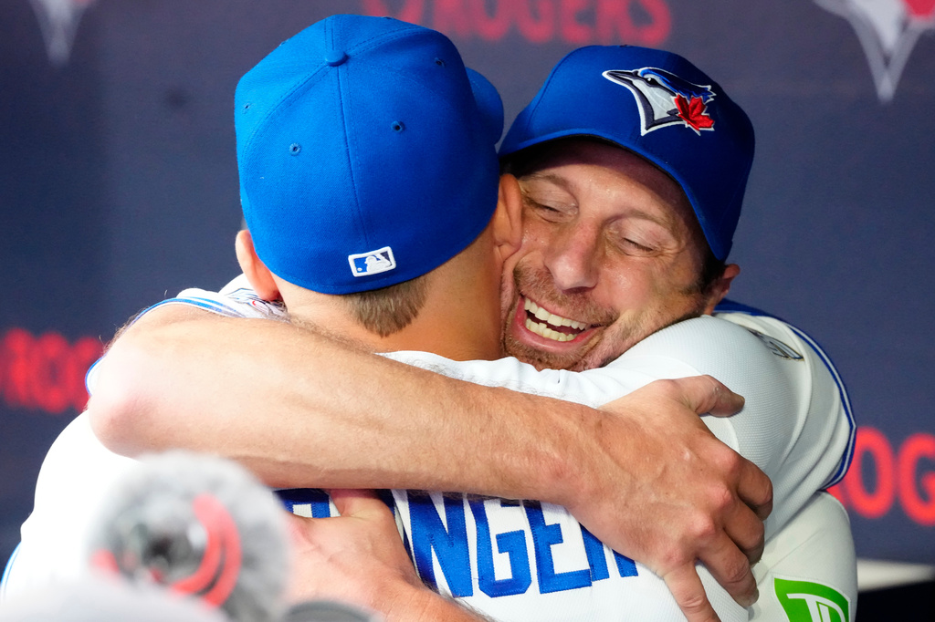 Toronto Blue Jays pitcher Max Scherzer (31) hugs teammate George Springer after being pulled in the eighth inning against the Cincinnati Reds during MLB baseball action in Toronto on Sunday, Sept. 27, 2026. (Frank Gunn/The Canadian Press via AP)