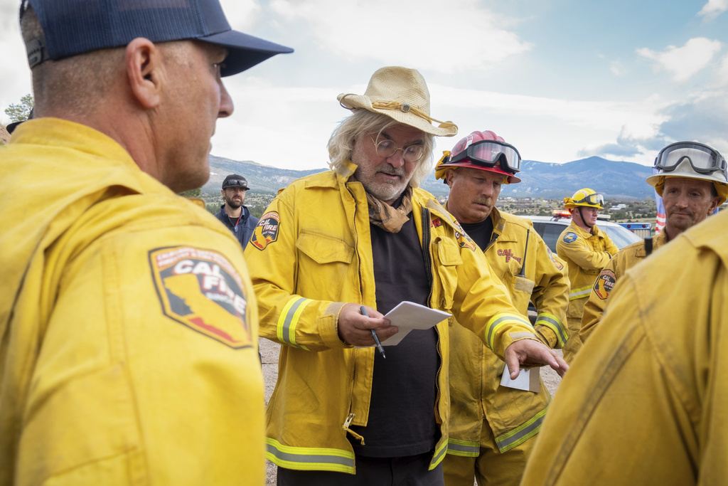 This image released by Apple TV+ shows filmmaker Paul Greengrass, center, suring the filming of "The Lost Bus." (Apple TV+ via AP)