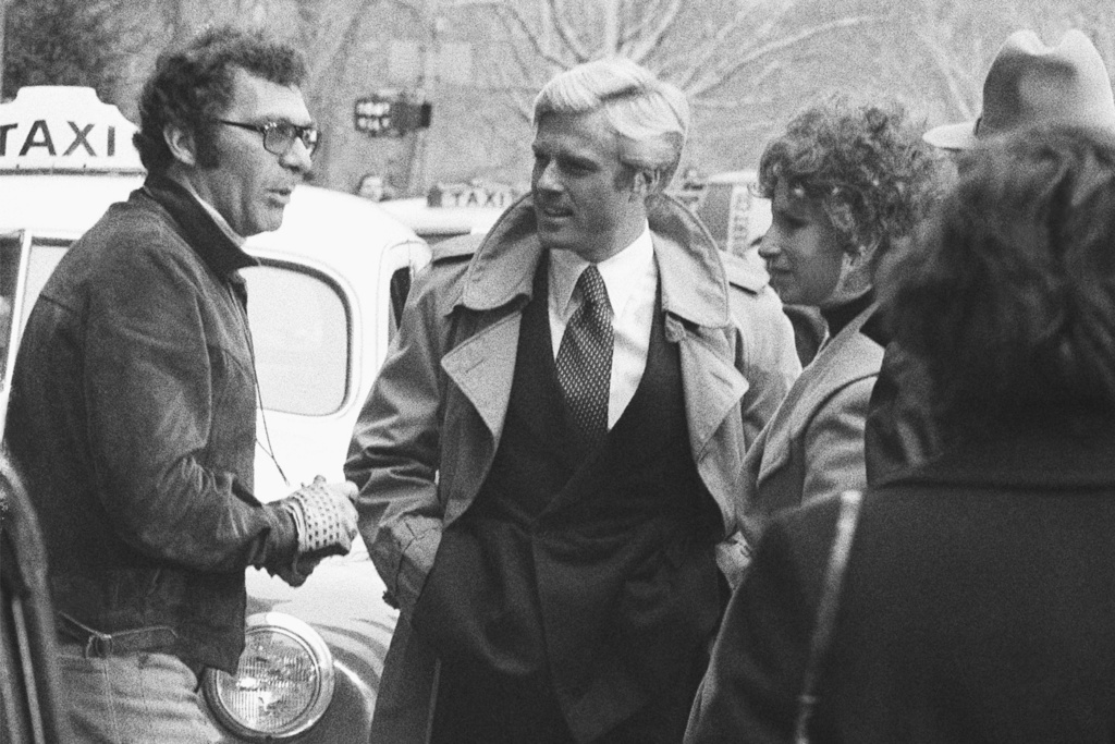 FILE - Director Sydney Pollack, left, appears with actors Robert Redford, center, and Barbra Streisand during the filming of "The Way We Were" in New York on Nov. 28, 1972. (AP Photo/Marty Lederhandler, File)