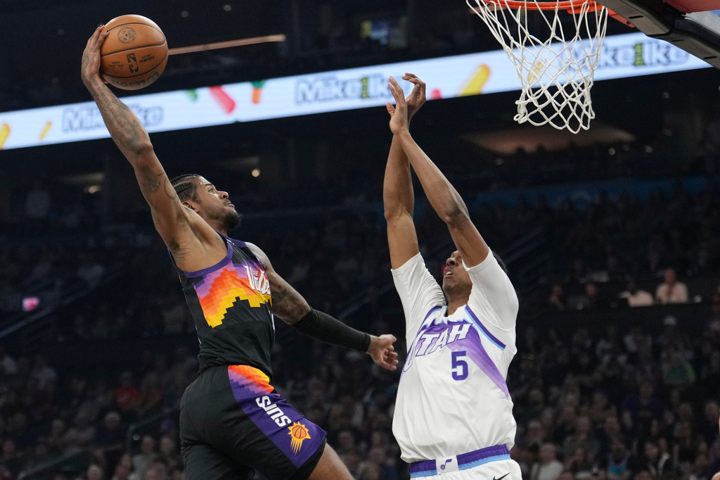 Phoenix Suns guard Jalen Green, left, goes up for a dunk against Utah Jazz forward Cody Williams (5) during the first half of an NBA basketball game, Saturday, March 28, 2026, in Phoenix. (AP Photo/Ross D. Franklin)