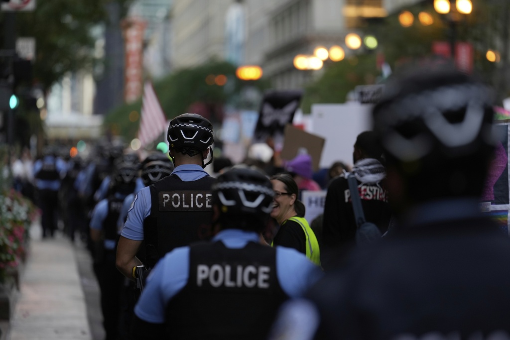 Police walk along as people march during Illinois Coalition for Immigrant & Refugee Rights' "Chicago Says No Trump No Troops" protest Saturday, Sept. 6, 2025, in Chicago. (AP Photo/Carolyn Kaster)
