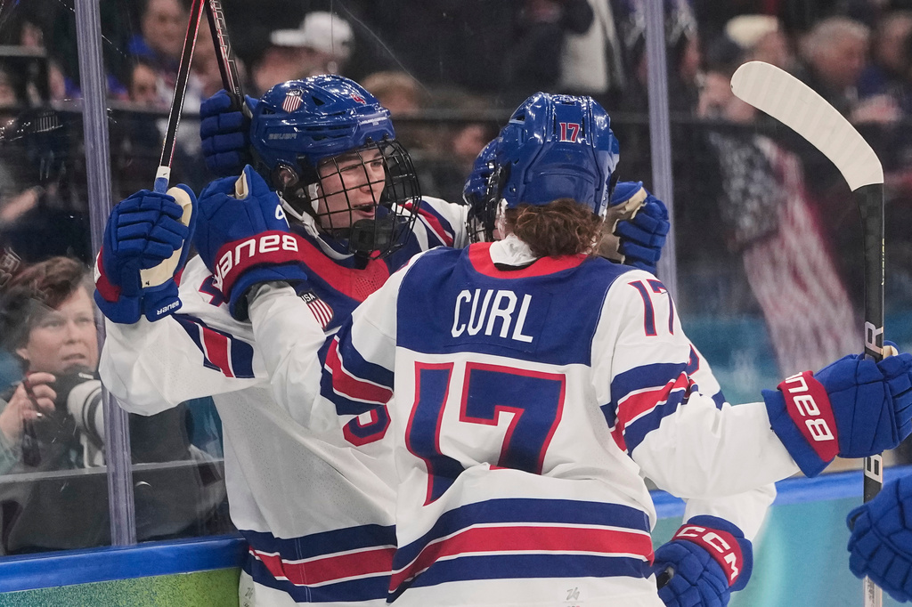 FILE - United States' Caroline Harvey celebrates with teammates after scoring her side's first goal during a preliminary round match of women's ice hockey between USA and Canada at the 2026 Winter Olympics, in Milan, Feb. 10, 2026. (AP Photo/Petr David Josek, File)