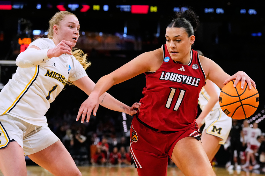 Louisville forward Elif Istanbulluoglu (11) works to the basket against Michigan guard Olivia Olson (1) in the first half in the Sweet 16 of the NCAA college basketball tournament, Saturday, March 28, 2026, in Fort Worth, Texas. (AP Photo/Tony Gutierrez)