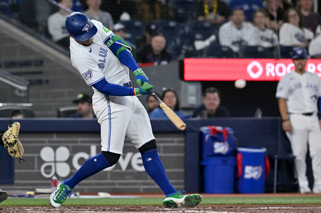 Toronto Blue Jays designated hitter George Springer hits a solo home run against the Colorado Rockies in third-inning baseball game action in Toronto, Monday, March 30, 2026. (Jon Blacker/The Canadian Press via AP)
