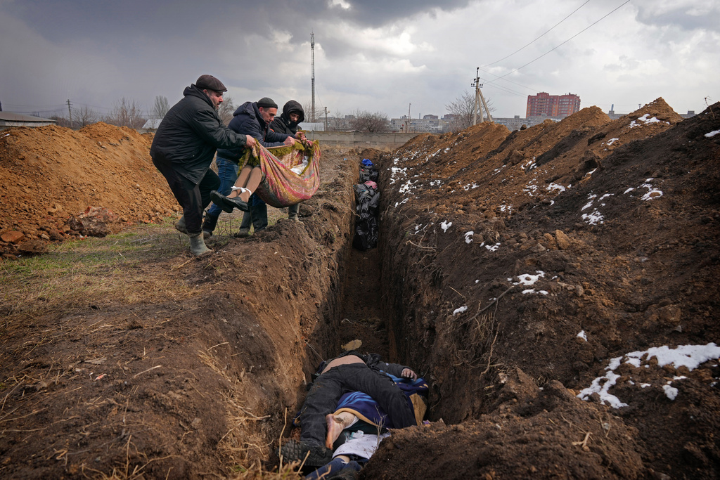 FILE - Bodies are placed into a mass grave on the outskirts of Mariupol, Ukraine, Wednesday, March 9, 2022. (AP Photo/Evgeniy Maloletka, File)