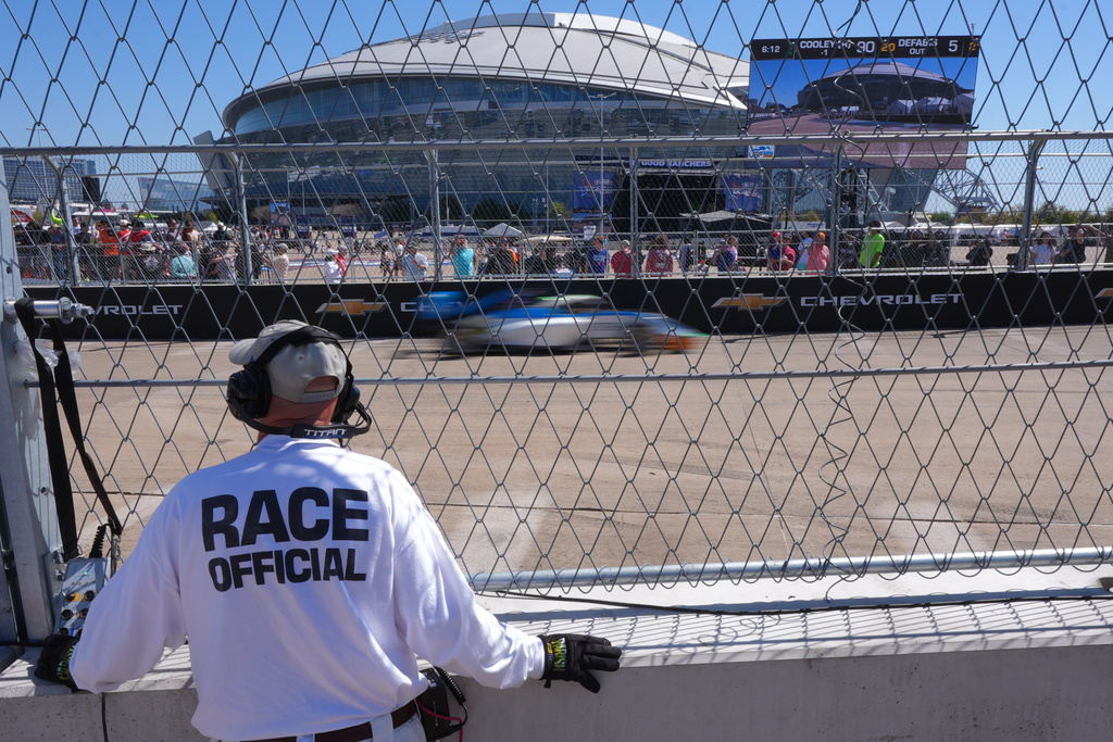A race official watches as IndyCars drive the track at the Grand Prix of Arlington auto race, Saturday, March 14, 2026, in Arlington, Texas. (AP Photo/LM Otero)