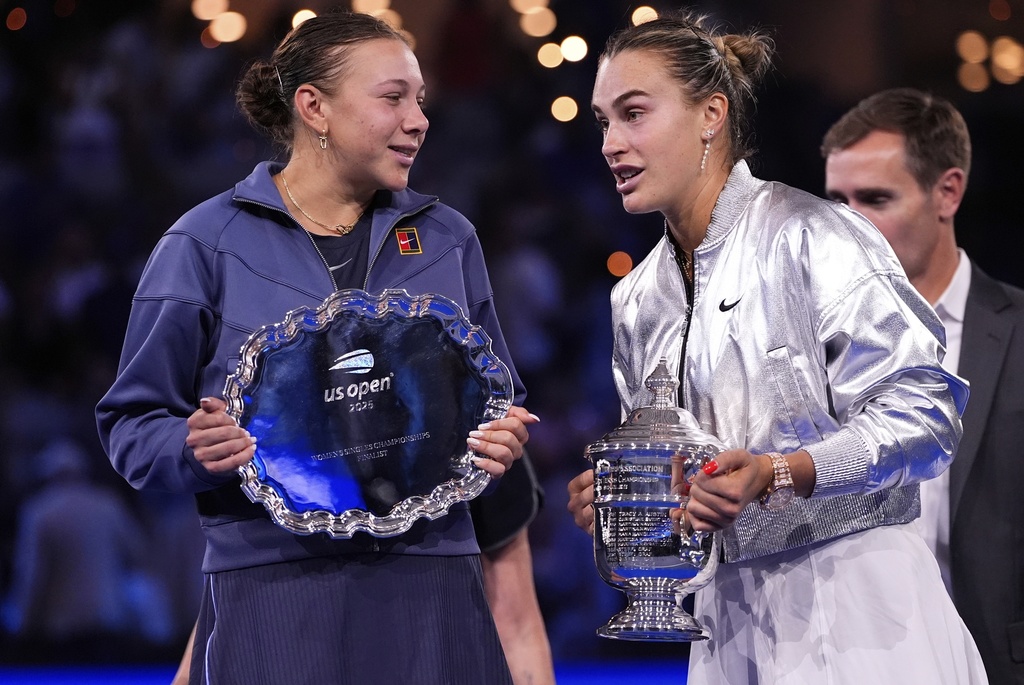 Aryna Sabalenka, of Belarus, and Amanda Anisimova, of the United States, jhold their trophies after the women's finals of the U.S. Open tennis championships, Saturday, Sept. 6, 2025, in New York. (AP Photo/Yuki Iwamura)