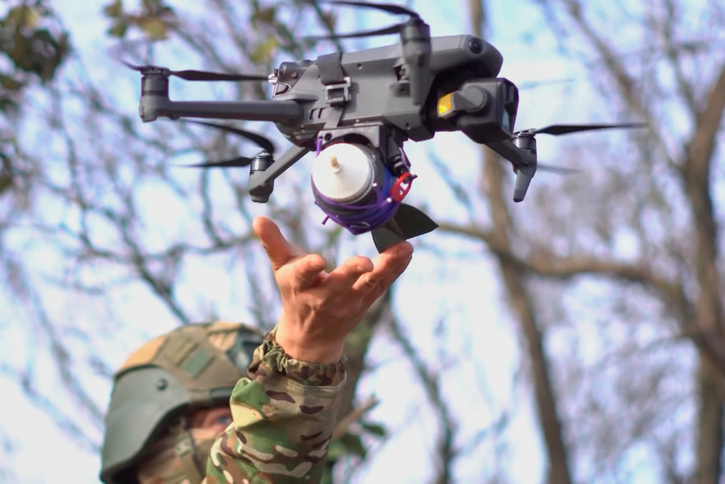 In this photo taken from a video provided by Russian Defense Ministry press service on Tuesday, Nov. 18, 2025, a Russian serviceman launches a drone with attached explosives at an undisclosed location in Ukraine. (Russian Defense Ministry Press Service via AP)