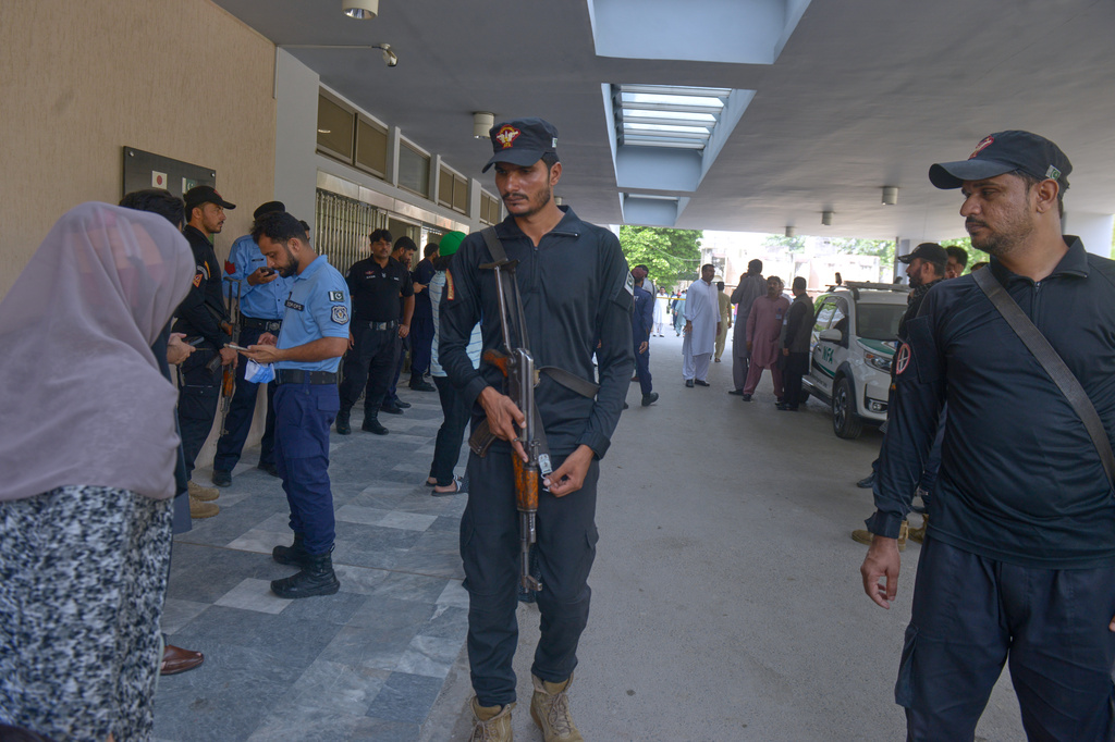 Police officers stand guard outside a nursery following a fire at a hospital in Islamabad, Pakistan, Wednesday, Aug. 26, 2026. (AP Photo/M.A. Sheikh)