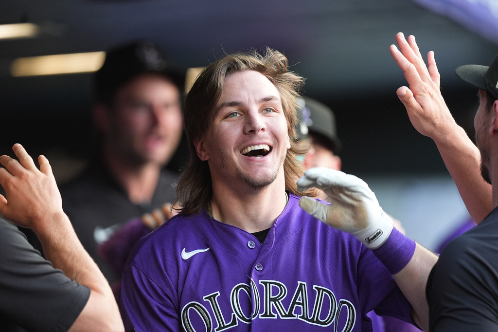 Colorado Rockies' Jake McCarthy is congratulated as he returns to the dugout after hitting an inside-the-park home run off Pittsburgh Pirates starting pitcher Paul Skenes in the first inning of a baseball game Saturday, June 20, 2026, in Denver. (AP Photo/David Zalubowski)