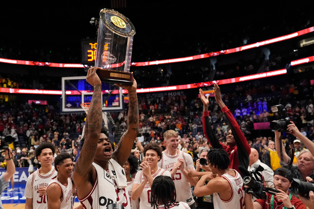 Arkansas forward Nick Pringle, left, raises the trophy after winning against Vanderbilt in an NCAA college basketball game in the final of the Southeastern Conference tournament Sunday, March 15, 2026, in Nashville, Tenn. (AP Photo/George Walker IV)