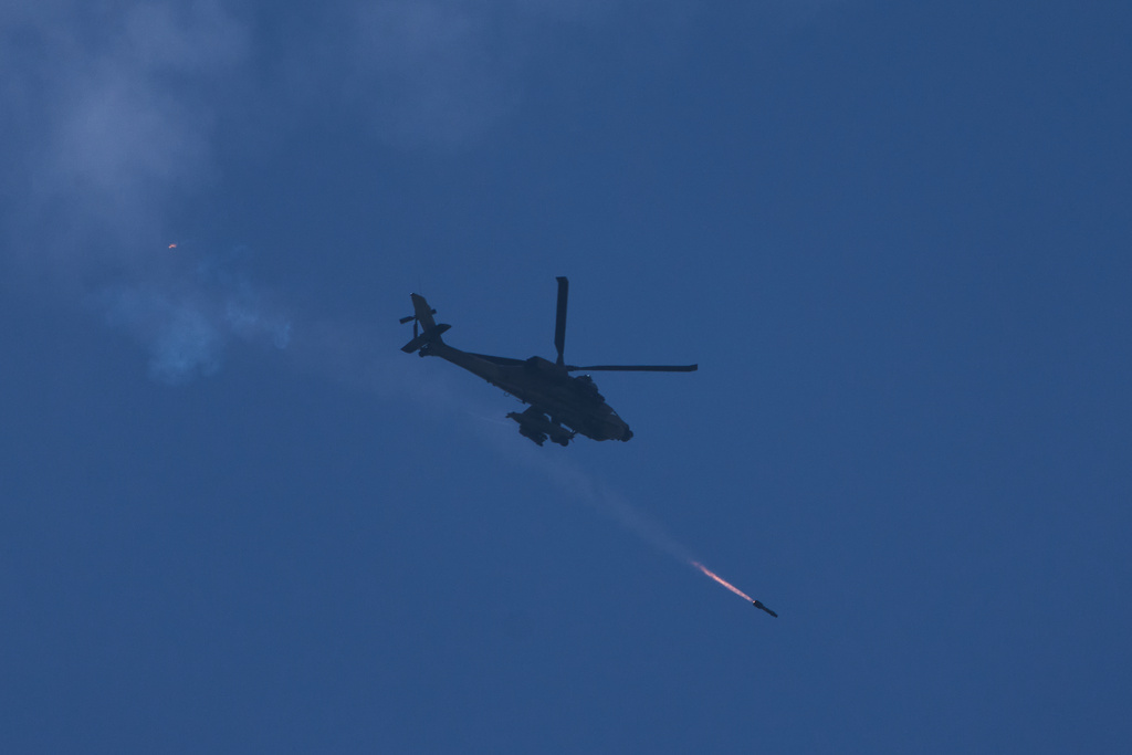 An Israeli Apache helicopter fires a missile towards southern Lebanon as seen form northern Israel, Monday, March 23, 2026. (AP Photo/Ariel Schalit)