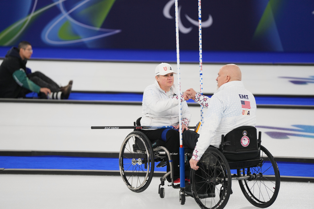 Steve Emt, right, and Laura Dwyer, of the United States, bump fists during their wheelchair curling mixed doubles round robin session against Japan at the 2026 Winter Paralympics, in Cortina d'Ampezzo, Italy, Thursday, March 5, 2026. (AP Photo/Evgeniy Maloletka)