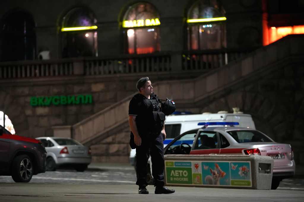 A policeman stands near the site where an improvised explosive device detonated at a restaurant in central Moscow, Saturday, Aug. 1, 2026. (AP Photo/Pavel Bednyakov)