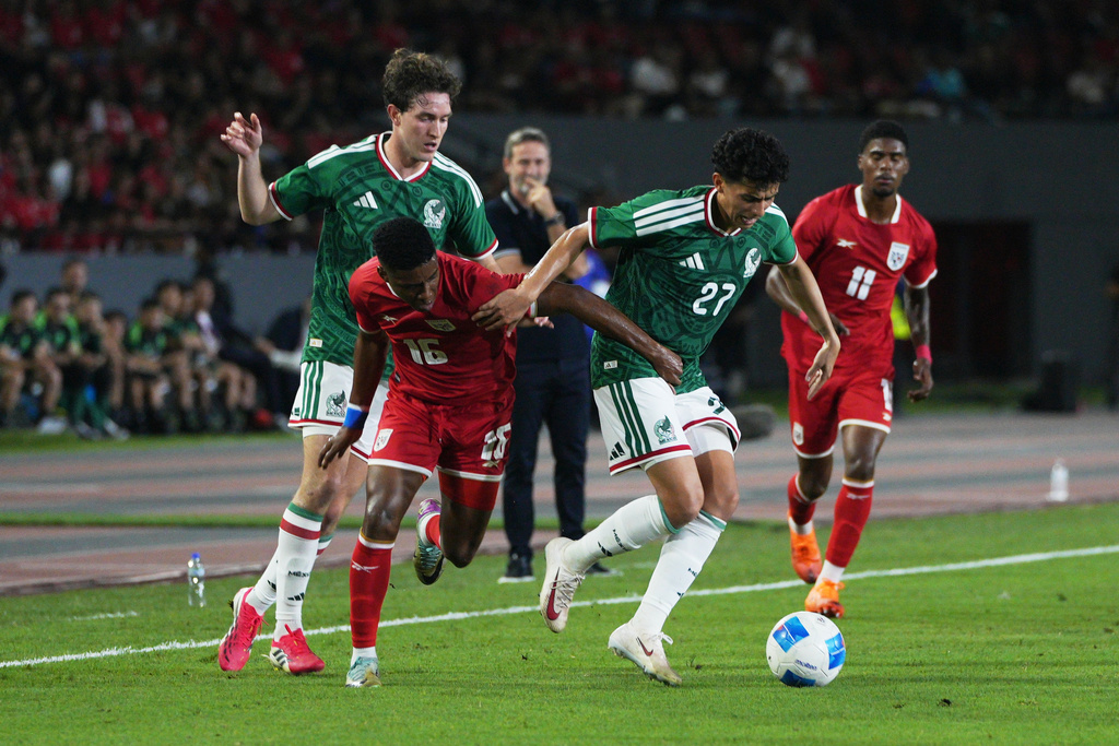 Panama's Kevin Galvan, left and Mexico's Richard Ledezma, right, vie for the ball during an international friendly soccer match in Panama City, Thursday, Jan. 22, 2026. (AP Photo/Agustin Herrera)