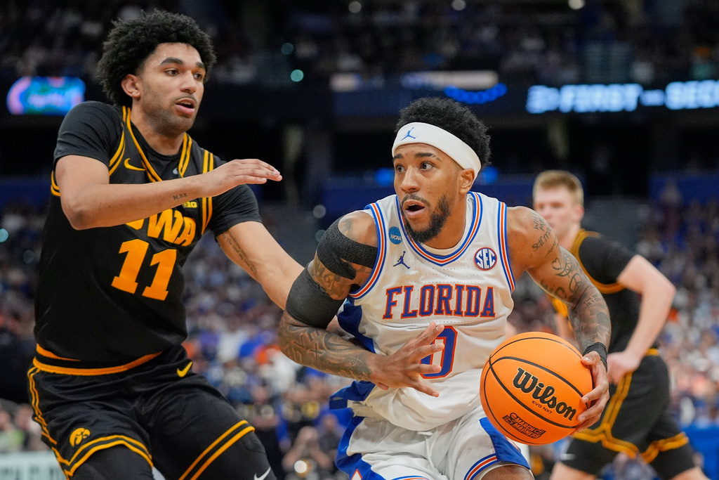 Florida guard Boogie Fland, right, drives around Iowa guard Kael Combs (11) during the first half in the second round of the NCAA college basketball tournament, Sunday, March 22, 2026, in Tampa, Fla. (AP Photo/John Raoux)