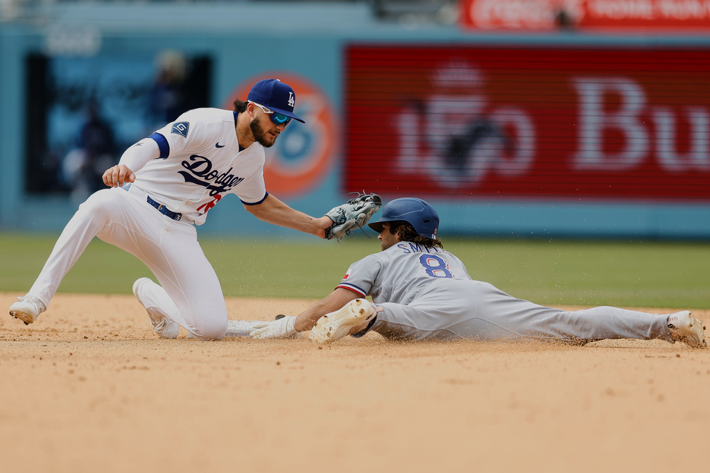 Texas Rangers' Josh Smith (8) slides into second base as Los Angeles Dodgers second baseman Alex Freeland (76) goes to tag him out at second base during the eighth inning of a baseball game Sunday, April 12, 2026, in Los Angeles. (AP Photo/Caroline Brehman)