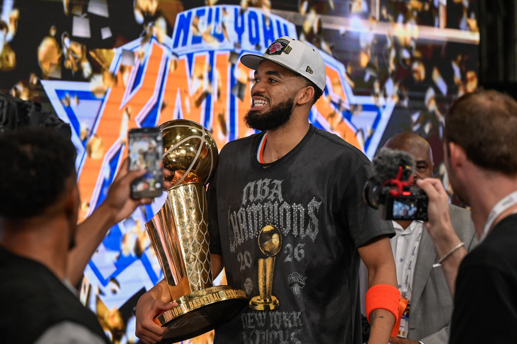 FILE - New York Knicks center Karl-Anthony Towns carries the Larry O'Brien Championship Trophy after the team defeated the San Antonio Spurs in Game 5 of the NBA Finals basketball series June 13, 2026, in San Antonio. (AP Photo/Darren Abate, File)