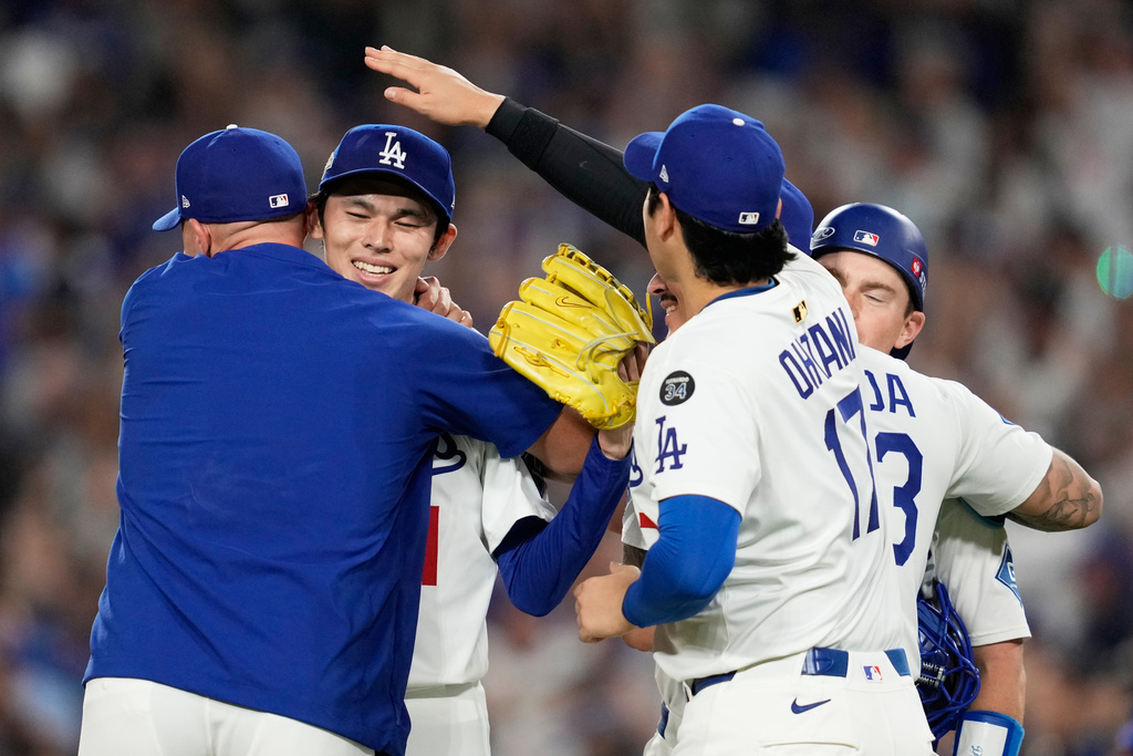 Los Angeles Dodgers pitcher Shohei Ohtani, catcher Will Smith and pitcher Roki Sasaki celebrates their win against the Milwaukee Brewers in baseball's National League Championship Series, Friday, Oct. 17, 2025, in Los Angeles. (AP Photo/Ashley Landis)