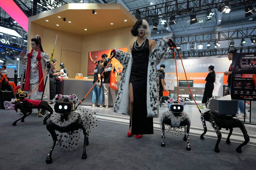 Models showing their robotic dogs with fancy dressing at a booth during the World Robot Conference at the Beiren Yichuang International Convention and Exhibition Centre in Beijing, Wednesday, Aug. 19, 2026. (AP Photo/Andy Wong)