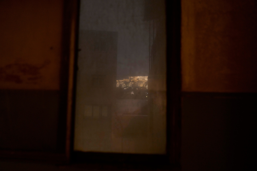 The 5th century B.C. Parthenon temple atop the Acropolis hill is seen through an old, dusty window in Athens, Saturday, Nov. 1 , 2025. (AP Photo/Petros Giannakouris)