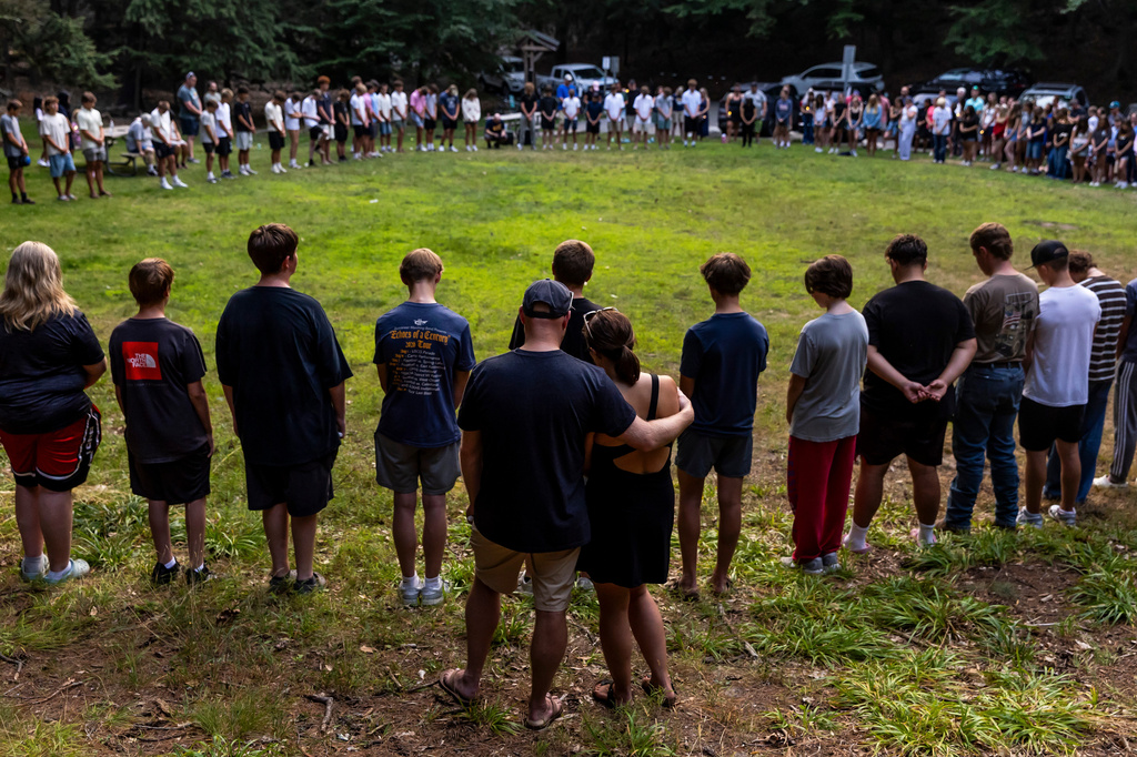 Community members gather during a student-organized vigil at Duncan Woods in Grand Haven, Mich. on Sunday, July 26, 2026, to grieve and honor eight members of a local family who died in a tragedy that has stunned the lakeshore community. (Isaac Ritchey /The Grand Rapids Press via AP)