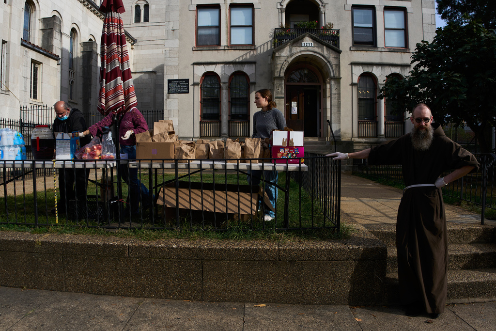 Capuchin Brother Stephen Wright, right, stands with other members of the Shrine of the Sacred Heart as they get ready to distribute groceries to parishioners who are afraid to leave home and go to the grocery store due to immigration raids in Washington, Oct. 11, 2025. (AP Photo/Luis Andres Henao)