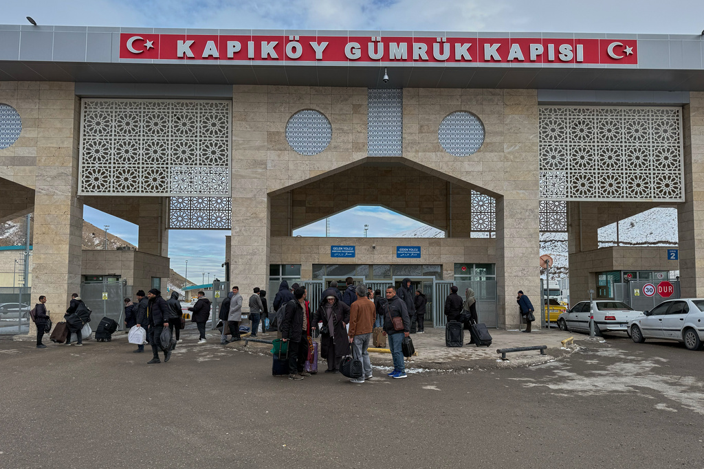 People, mostly Iranians, wait after crossing Kapikoy border post between Turkey and Iran, in Kapikoy, Turkey, Saturday, Jan. 17, 2026. (AP Photo/Serra Yedikardes)