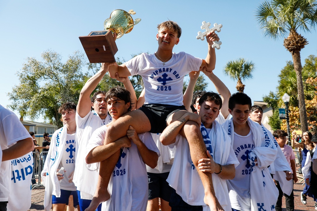 Athos Karistinos, 18, of Tarpon Springs, is carried by fellow cross divers as they celebrate his victory during the annual cross dive in the Spring Bayou, part of the Epiphany celebration on Tuesday, Jan. 6, 2026, in Tarpon Springs, Fla. (Jefferee Woo /Tampa Bay Times via AP)