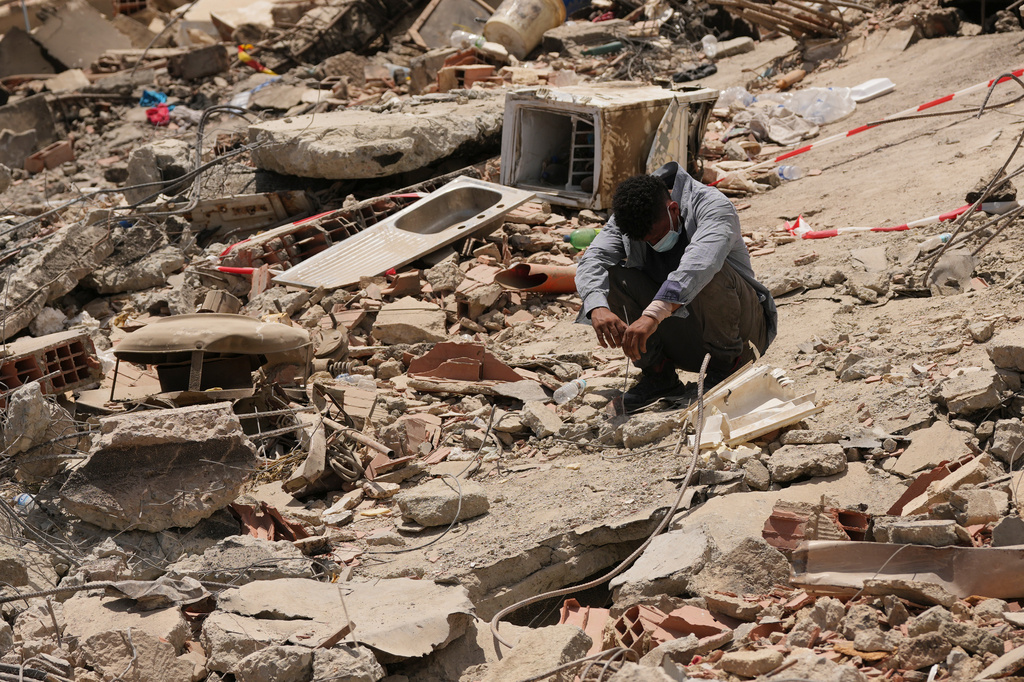 FILE - A man sits amid earthquake rubble in La Guaira, Venezuela, June 29, 2026. (AP Photo/Matias Delacroix, File)