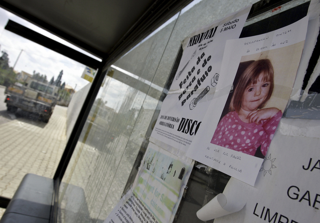 FILE -A photo of 3-year-old British girl Madeleine McCann is pasted on a board at a bus stop near the resort from where she went missing, May 4, 2007, in Praia da Luz, southern Portugal, where she was on vacation with her family. (AP Photo/Armando Franca, File)