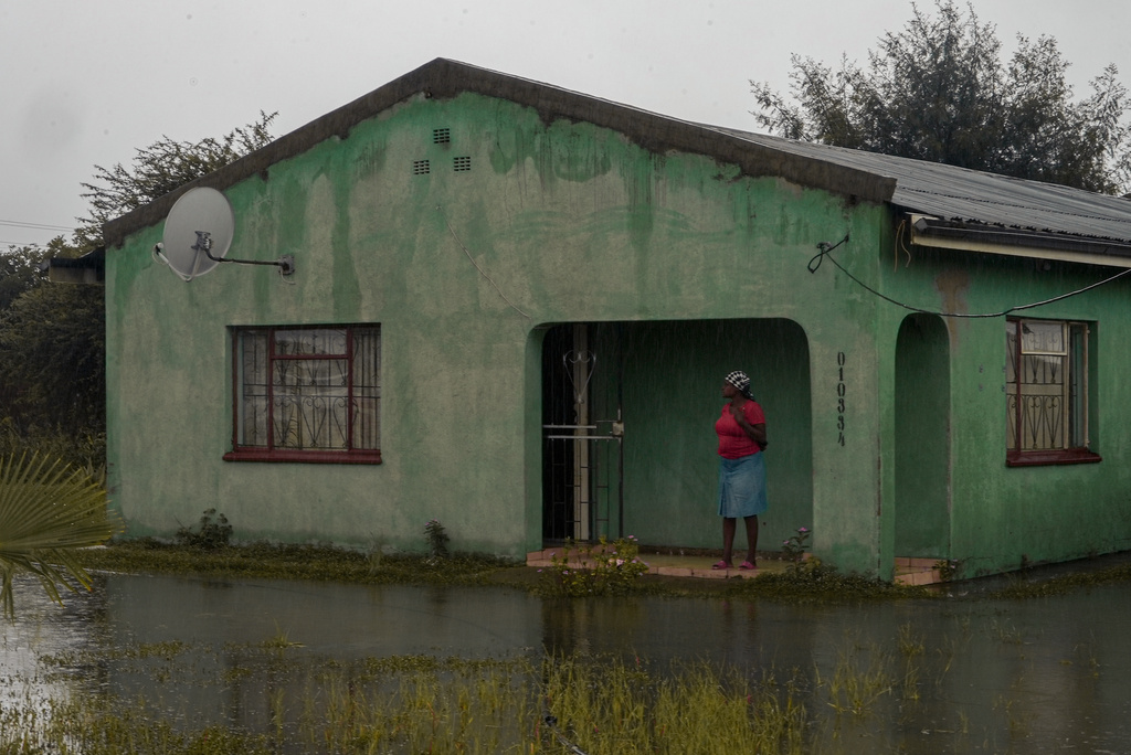 A woman stands outside a flooded house in Nkomazi, Mpumalanga Province, South Africa, on Friday, Jan. 16, 2026. (AP Photo/Alfonso Nqunjana)