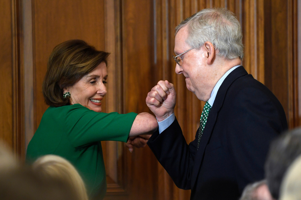 FILE - House Speaker Nancy Pelosi of Calif., left, and Senate Majority Leader Mitch McConnell of Ky., right, bump elbows as they attend a lunch with Irish Prime Minister Leo Varadkar on Capitol Hill in Washington, March 12, 2020. (AP Photo/Susan Walsh, File)