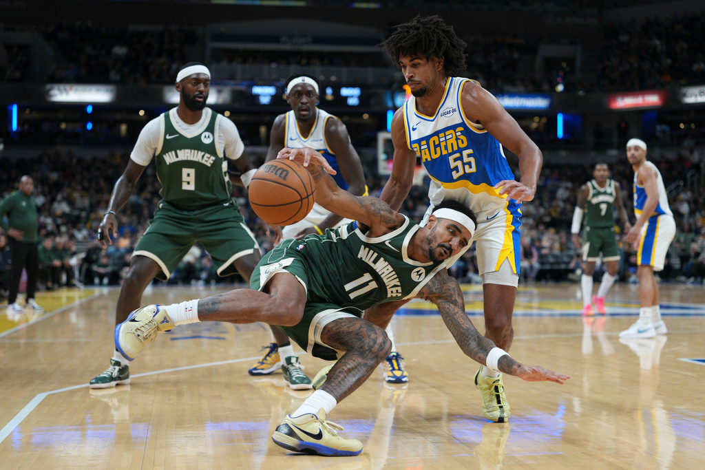 Milwaukee Bucks guard Gary Harris (11) slips in front of Indiana Pacers guard Ethan Thompson (55) during the second half of an NBA basketball game in Indianapolis, Tuesday, Dec. 23, 2025. (AP Photo/AJ Mast)