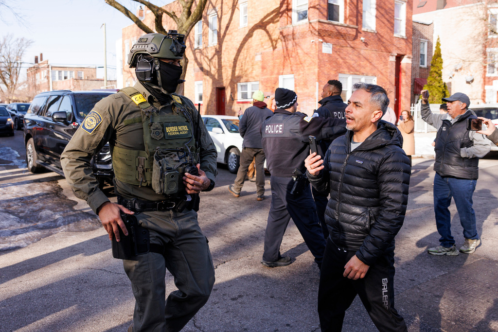 Federal immigration enforcement agents ask to clear the area after they detain an individual at West 27th Street and South Ridgeway Avenue in the Little Village neighborhood of Chicago, Tuesday, Dec. 16, 2025. (Anthony Vazquez/Chicago Sun-Times via AP)