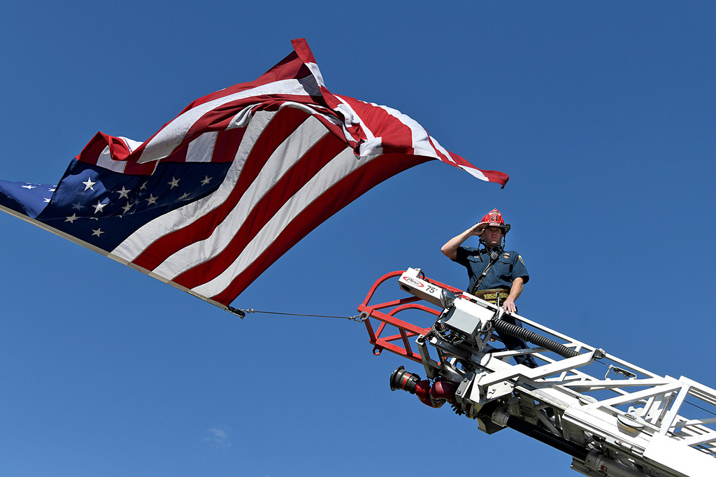 A captain with the Clifton Fire Protection District salutes the passing procession carrying the bodies of three firefighters killed while fighting the Snyder Fire in Grand Junction, Colo. Sunday, June 28, 2026. (Gretel Daugherty via AP)