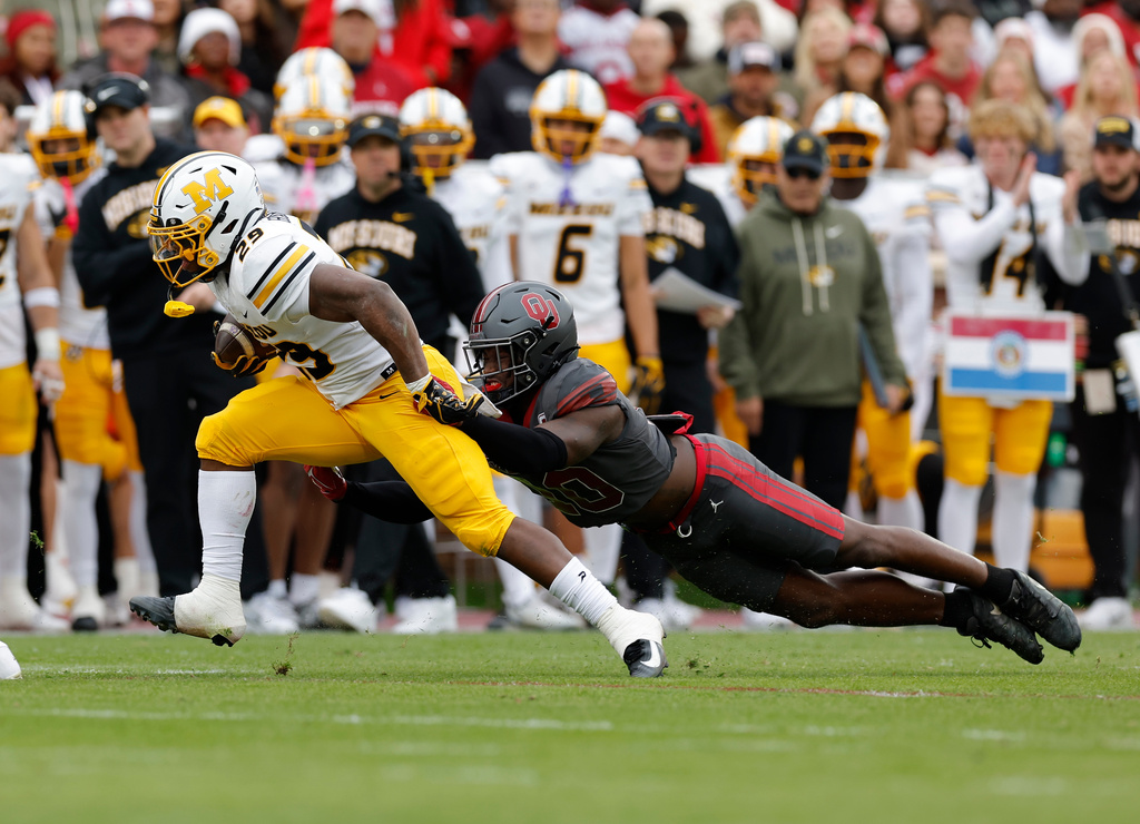 Missouri running back Ahmad Hardy (29) is tackled by Oklahoma linebacker Kip Lewis (10) during the first half of an NCAA college football game Saturday, Nov. 22, 2025, in Norman, Okla. (AP Photo/Alonzo Adams)