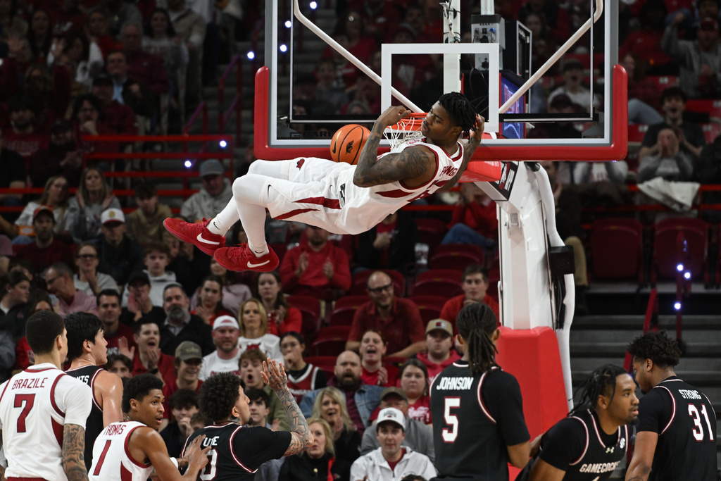 Arkansas forward Nick Pringle (23) dunks the ball over South Carolina defenders during the first half of an NCAA college basketball game Wednesday, Jan. 14, 2026, in Fayetteville, Ark. (AP Photo/Michael Woods)