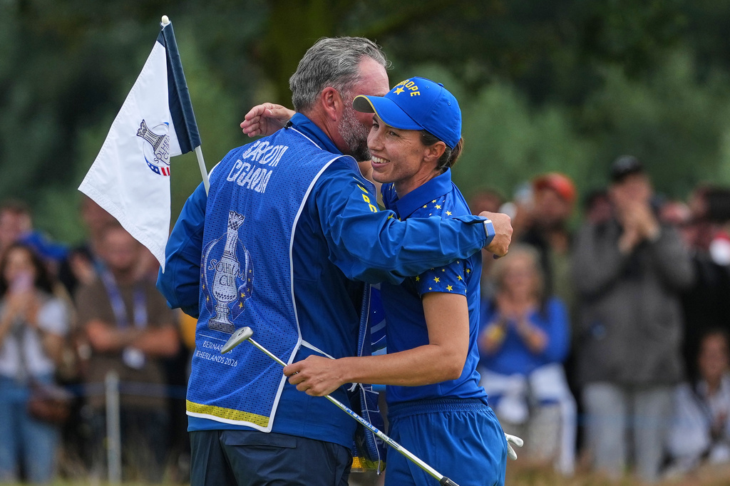 Carlota Ciganda of Europe embraces her caddie on the 16th green after beating Jennifer Kupcho of the United States in a singles match during the final day of the Solheim Cup in Den Bosch, Netherlands, Sunday, Sept. 13, 2026. (AP Photo/Alastair Grant)