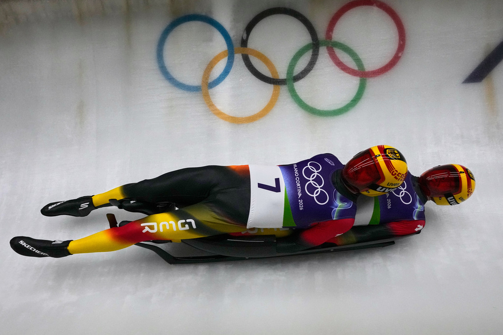 Germany's Toni Eggert, left, and Florian Mueller, right, slide down the track during a men's doubles luge run at the 2026 Winter Olympics, in Cortina d'Ampezzo, Italy, Wednesday, Feb. 11, 2026. (AP Photo/Aijaz Rahi)