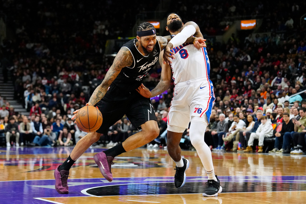 Philadelphia 76ers forward Paul George (8) fouls Toronto Raptors forward Brandon Ingram, left, during the first half of an NBA basketball game in Toronto, Monday, Jan. 12, 2026. (Frank Gunn/The Canadian Press via AP)