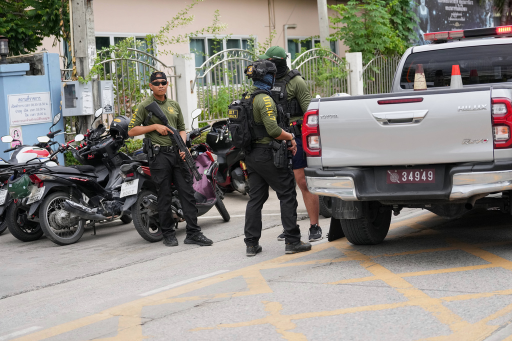 Police stand guard after a shooting at the Debsirin Nonthaburi School in Thailand's Nonthaburi province, Friday, Aug. 7, 2026. (AP Photo/Sakchai Lalit)