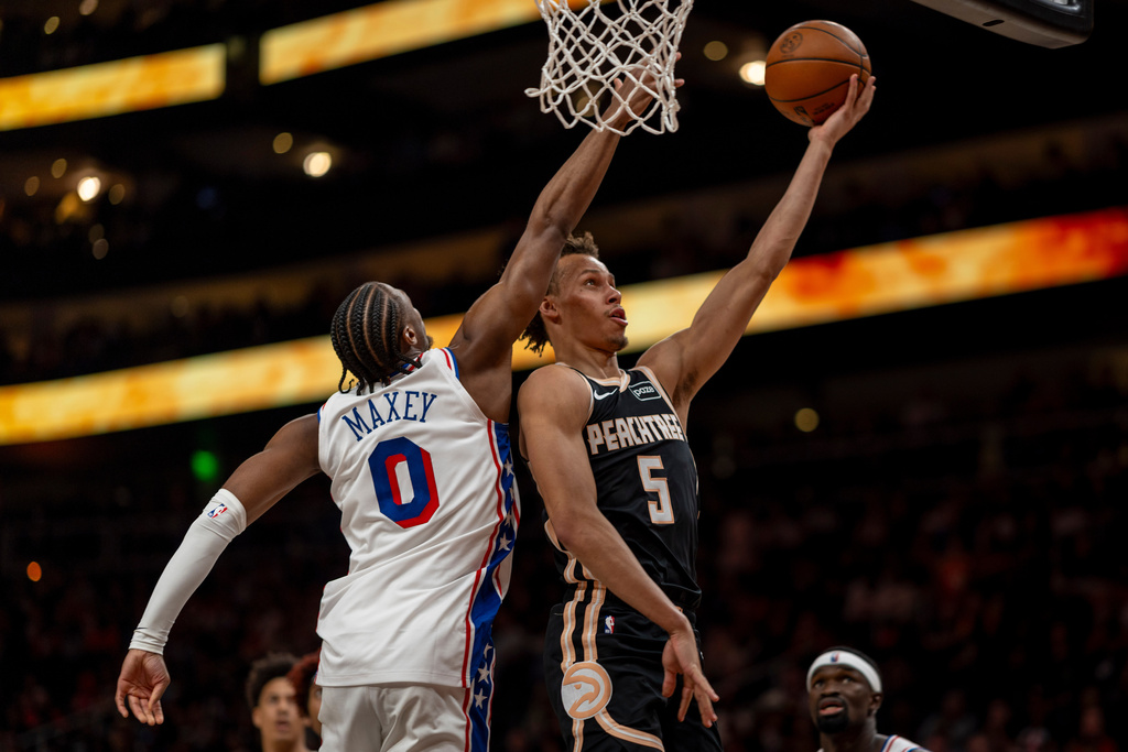 Atlanta Hawks guard Dyson Daniels (5) makes a basket against Philadelphia 76ers guard Tyrese Maxey (0) during the first half of an NBA basketball game, Saturday, March 7, 2026, in Atlanta. (AP Photo/Erik Rank)