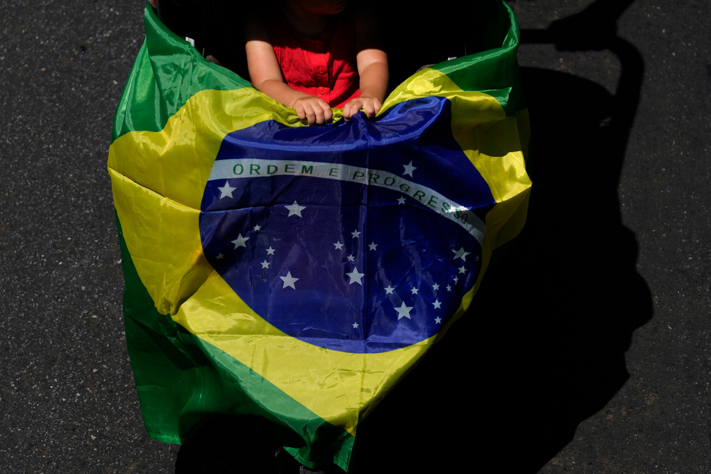 A child holds a Brazilian flag during an election campaign march in support of Brazilian President Luiz Inacio Lula da Silva, who is running for reelection, in Brasilia, Brazil, Sunday, Sept. 13, 2026. (AP Photo/Eraldo Peres)