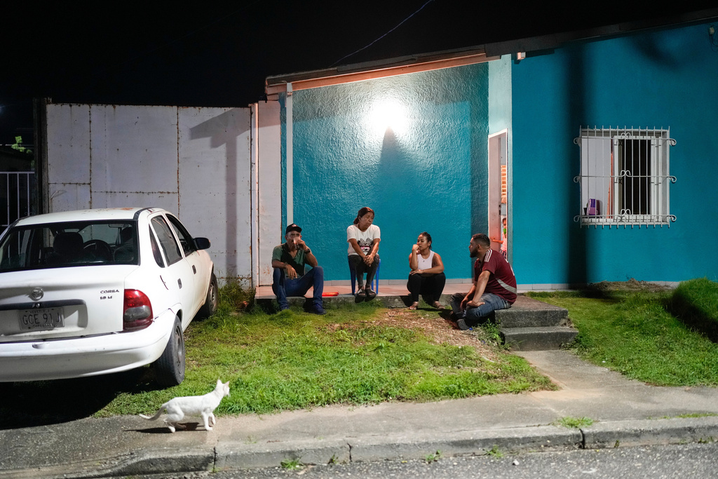 Gabriela Villanueva, third from left, and her husband Juan Guedez, right, sit with her in-laws outside their home in Araure, Venezuela, June 11, 2025. The couple traveled by land from Chile to Mexico, crossing the Darien Gap in an attempt to reach the U.S., but returned home after the Trump administration closed the border to asylum seekers. (AP Photo/Matias Delacroix)