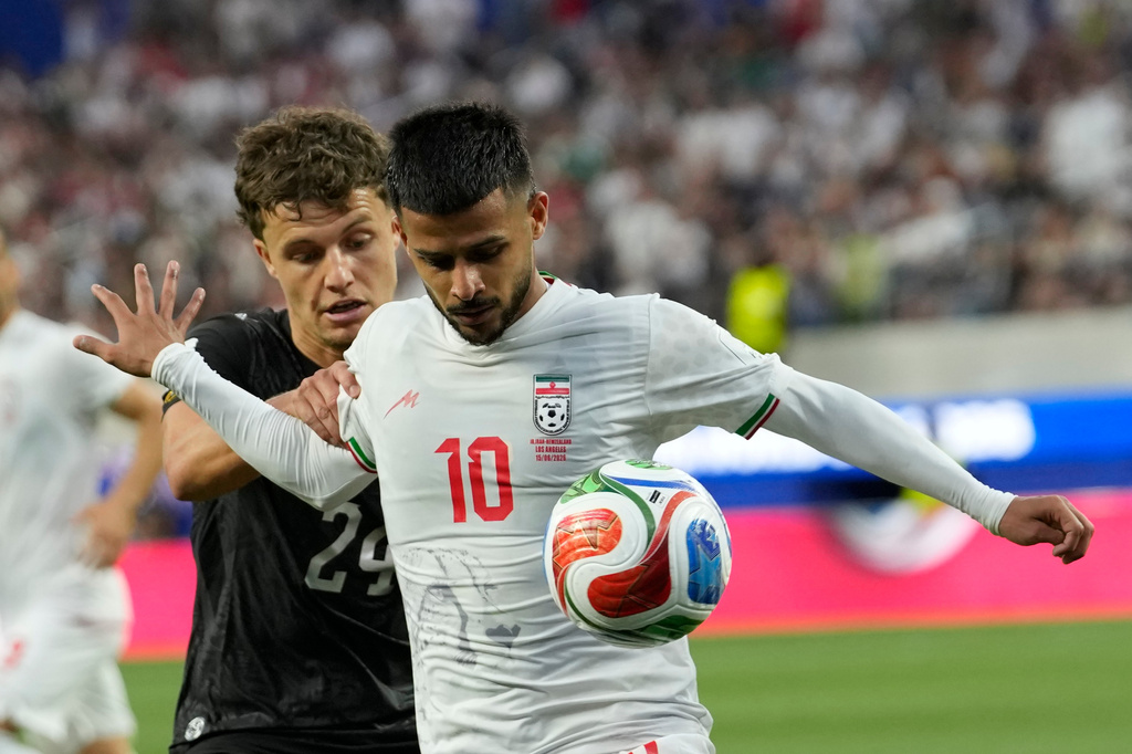 Iran's Mehdi Ghayedi (10) battles for the ball with New Zealand's Callan Elliot (24) during the World Cup Group G soccer match between Iran and New Zealand in Inglewood, Calif., near Los Angeles, Monday, June 15, 2026. (AP Photo/Andre Penner)
