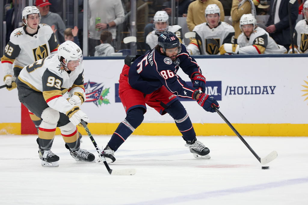 Columbus Blue Jackets right wing Kirill Marchenko (86) controls the puck as Vegas Golden Knights right wing Mitch Marner (93) plays defense during the second period of an NHL hockey game, Saturday, Dec. 13, 2025, in Columbus, Ohio. (AP Photo/Joe Maiorana)