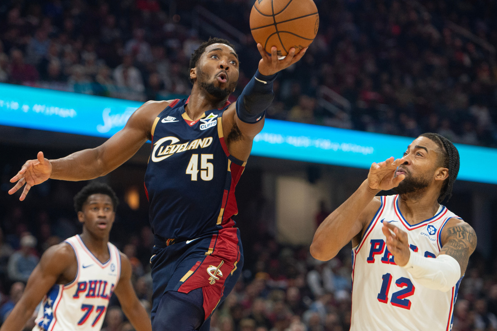 Cleveland Cavaliers' Donovan Mitchell (45) shoots as Philadelphia 76ers' Trendon Watford (12) looks on during the first half of an NBA basketball game in Cleveland, Wednesday, Nov. 5, 2025. (AP Photo/Phil Long)
