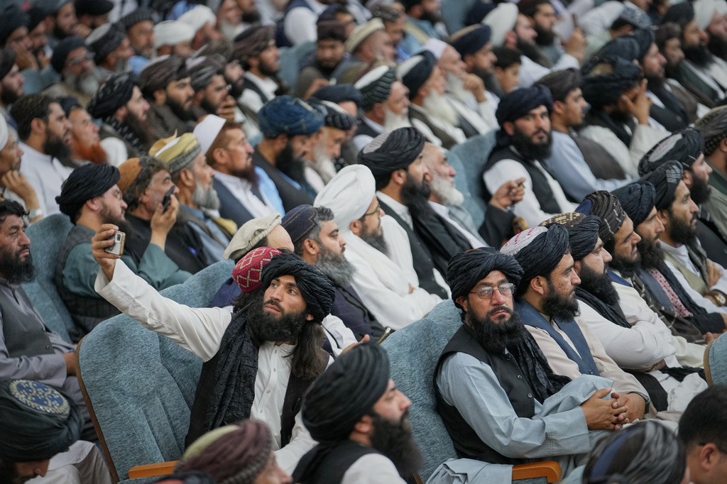 A Taliban delegate takes a selfie as he attends the opening meeting for celebrations marking the fifth anniversary of the U.S. withdrawal and the start of Taliban rule, at the Loya Jirga Hall in Kabul, Afghanistan, Saturday, Aug. 15, 2026. (AP Photo/Siddiqullah Alizai)
